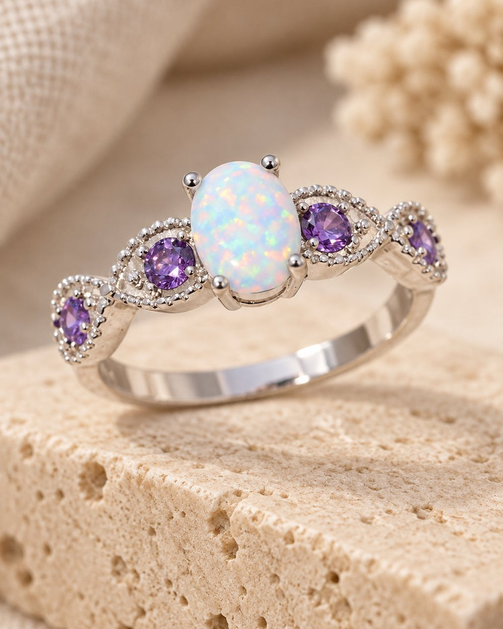 White Fire Opal Amethyst Ring on a travertine block
