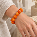Big amber-tone bead bracelet worn on a woman's wrist