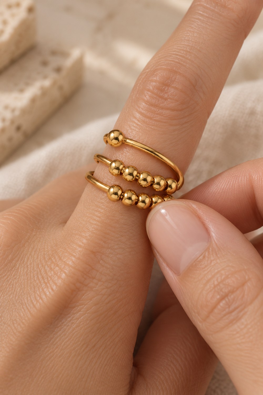 A thumb rolling the beads of the bead spinner ring