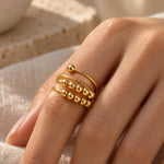 Gold-tone triple coil bead spinner ring worn on a woman's finger