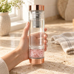 Crystal Elixir Water Bottle with a rose quartz pod, held in a woman's hand