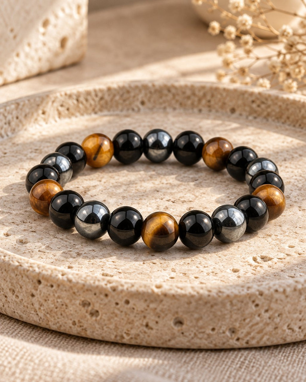 Tiger eye, obsidian and hematite bead bracelet on a travertine tray