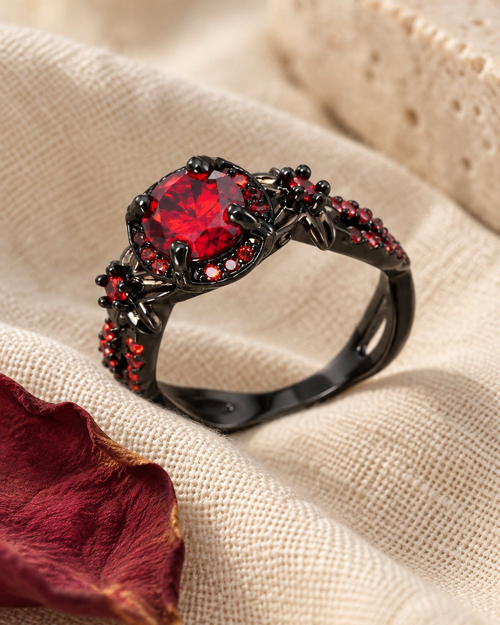 Flower Ruby Black Gold Ring on cream linen beside a dried rose petal
