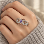 Two-Tone Heart & Rose Ring with a purple stone, worn on a woman's finger