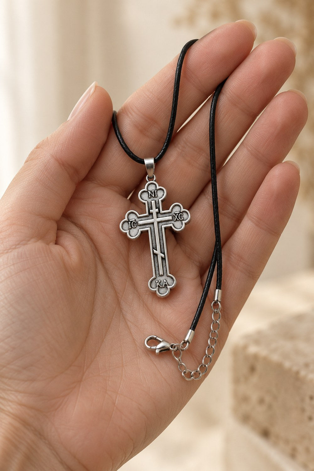 IC XC NIKA Orthodox cross necklace resting in an open palm