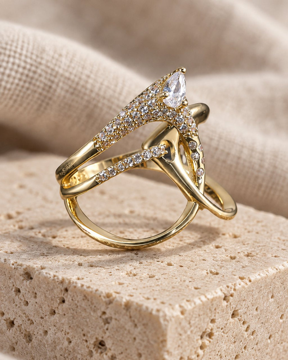 Marquise Crossover Ring standing on a travertine block