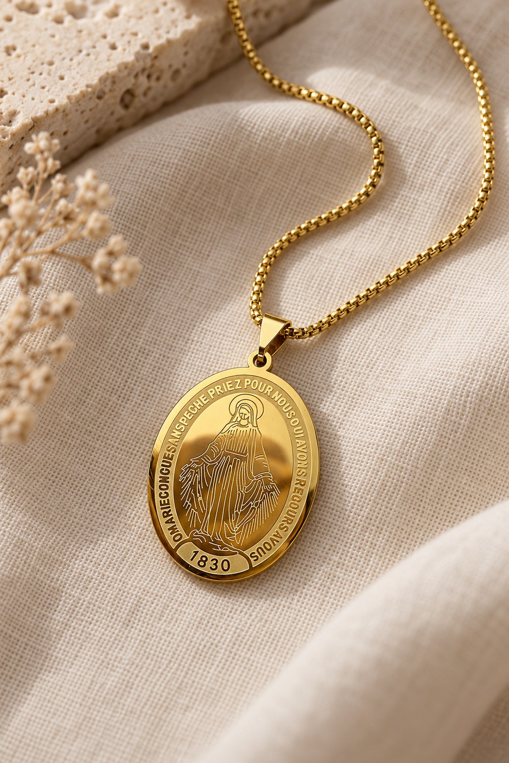 Gold-tone Miraculous Medal and box chain on cream linen