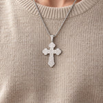 Silver-tone Orthodox crucifix necklace worn over an oatmeal sweater