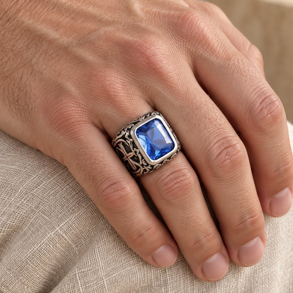 Sapphire-blue signet ring with carved shoulders, worn on a man's finger