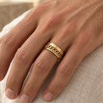 Roman Numeral Spinner Ring in gold-tone, worn on a man's ring finger