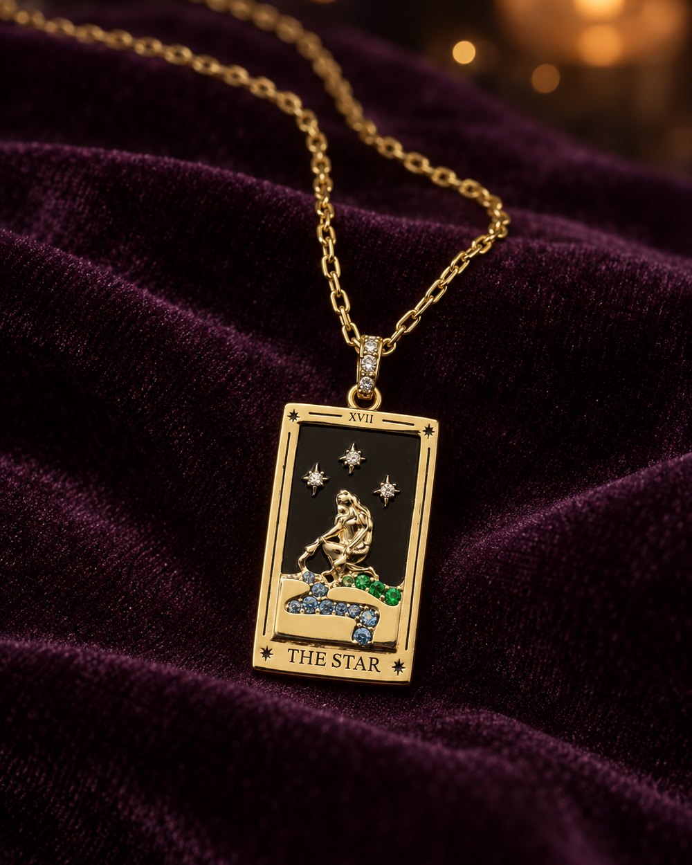 The Star tarot card pendant in gold-plated steel, lying on velvet