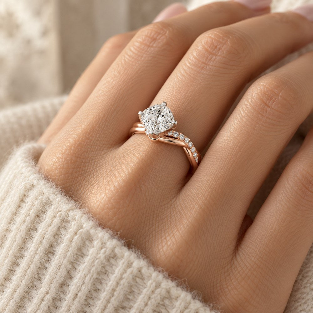 Twisted band solitaire ring in rose gold tone, worn on a woman's finger
